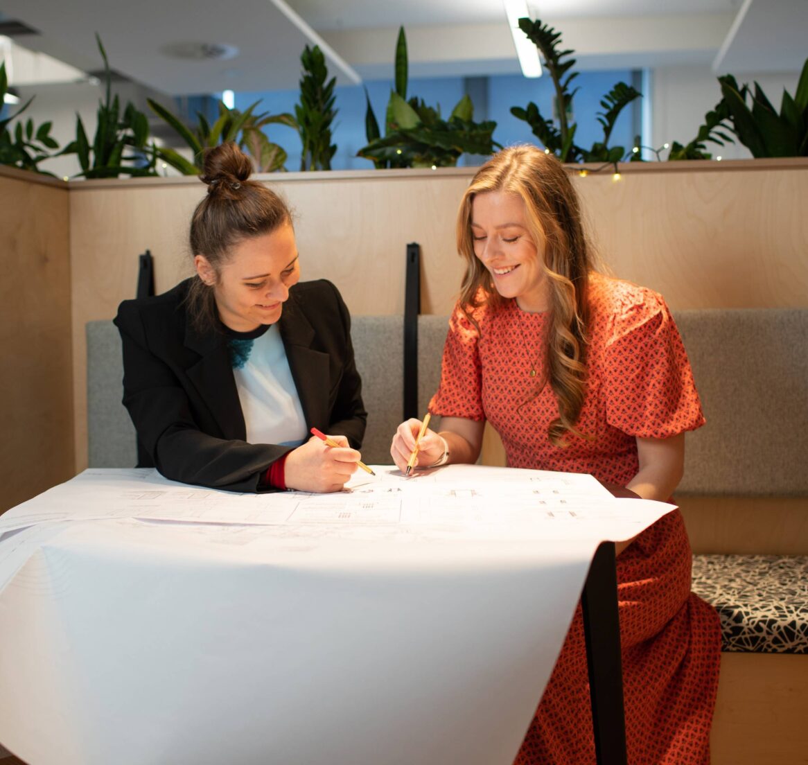 Two people looking at a drawing in an office