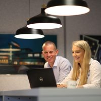 Two people looking a laptop