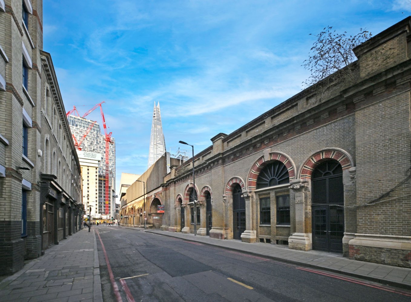 Street view showing the building with arched windows and doors