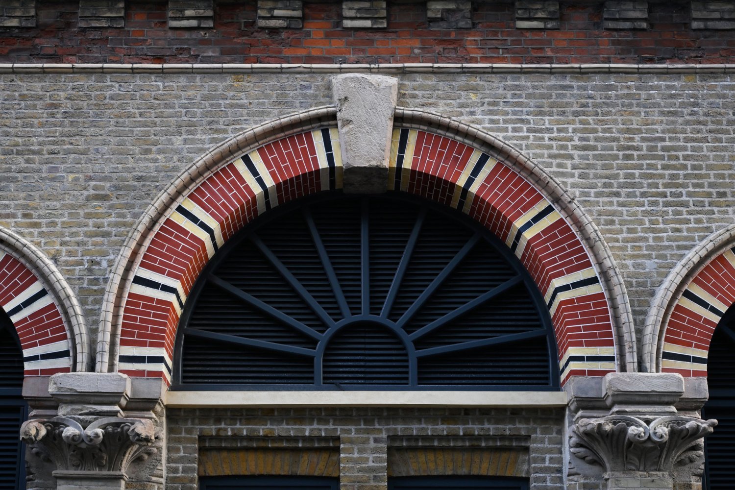 An arched window frame surrounded with red brick detailing