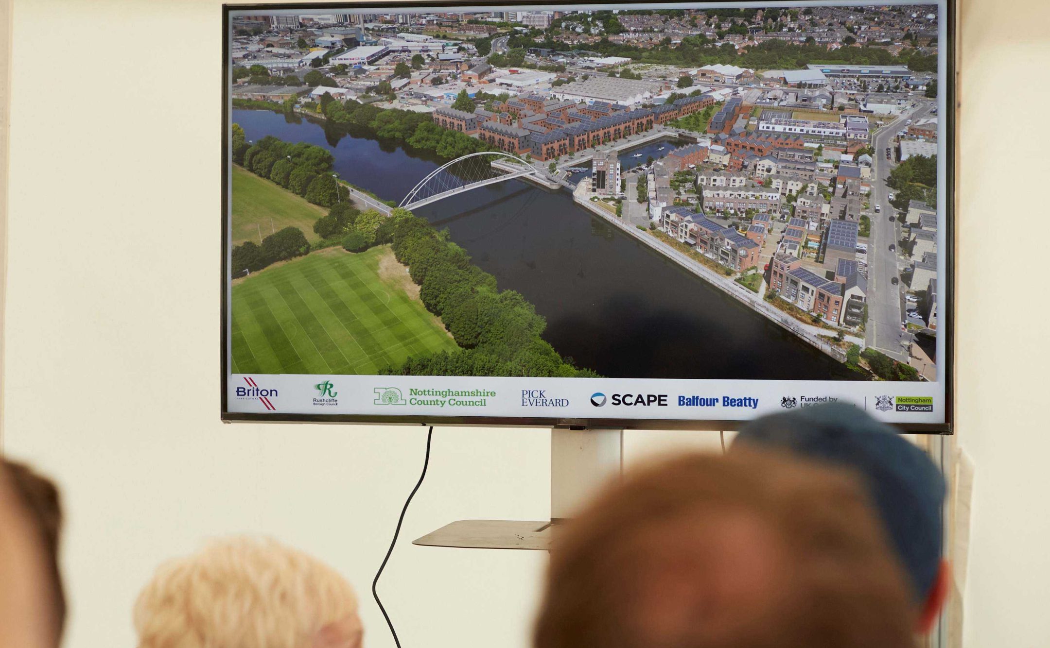 TV screen showing the CGI image of how the bridge will look once installed over the river
