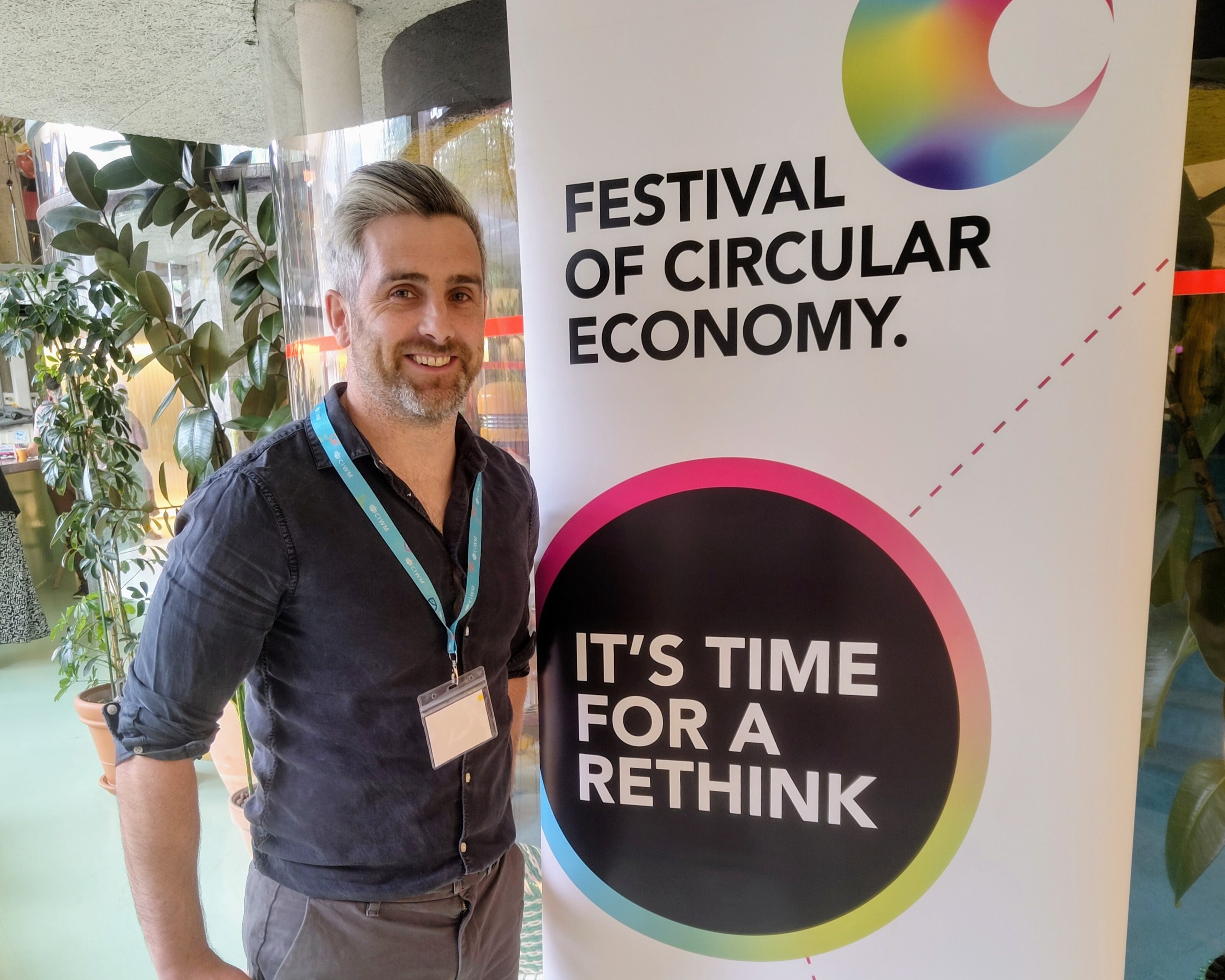 Jonny Burke nest to banner at event