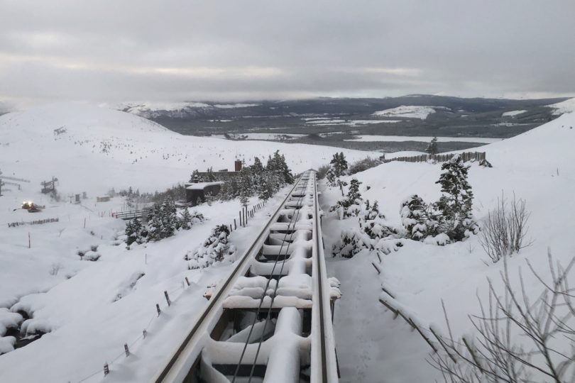 Snow covering train tracks running up the side of a mountain
