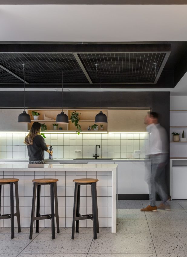 Internal of a workplace kitchen with people chatting