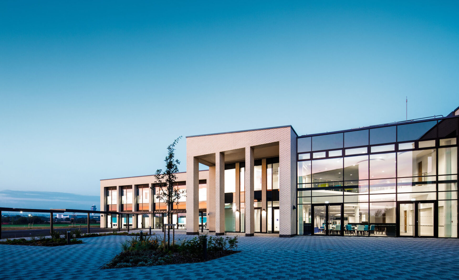 A photo of the outside of the school with blue skies and clean gardens