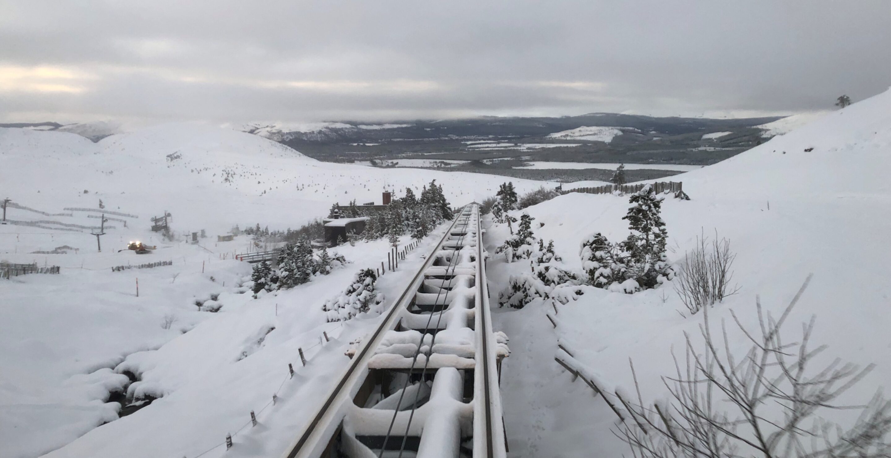 Snow covering train tracks running up the side of a mountain
