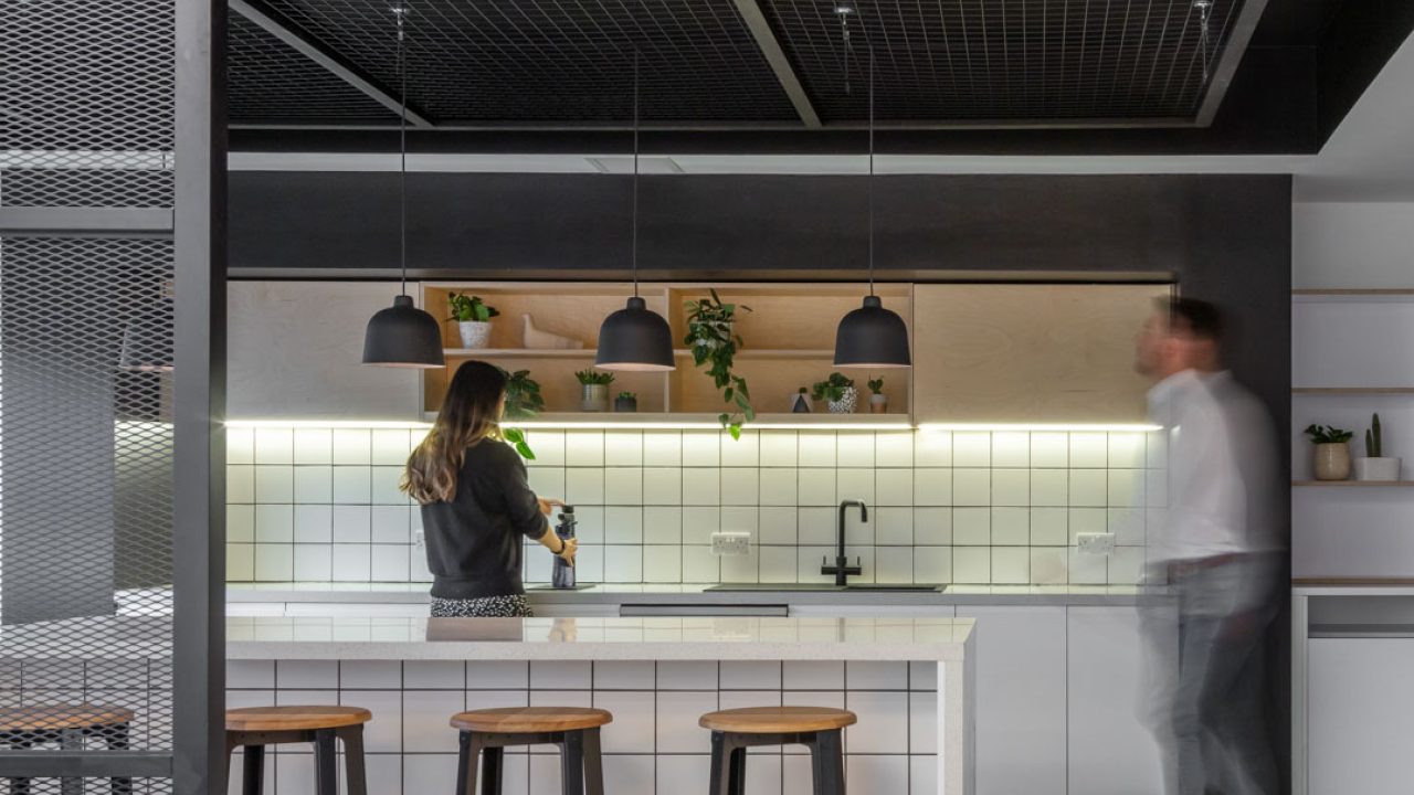 Internal of a workplace kitchen with people chatting