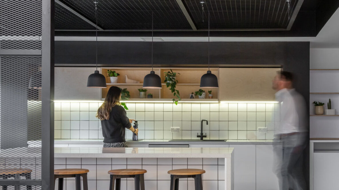 Internal of a workplace kitchen with people chatting