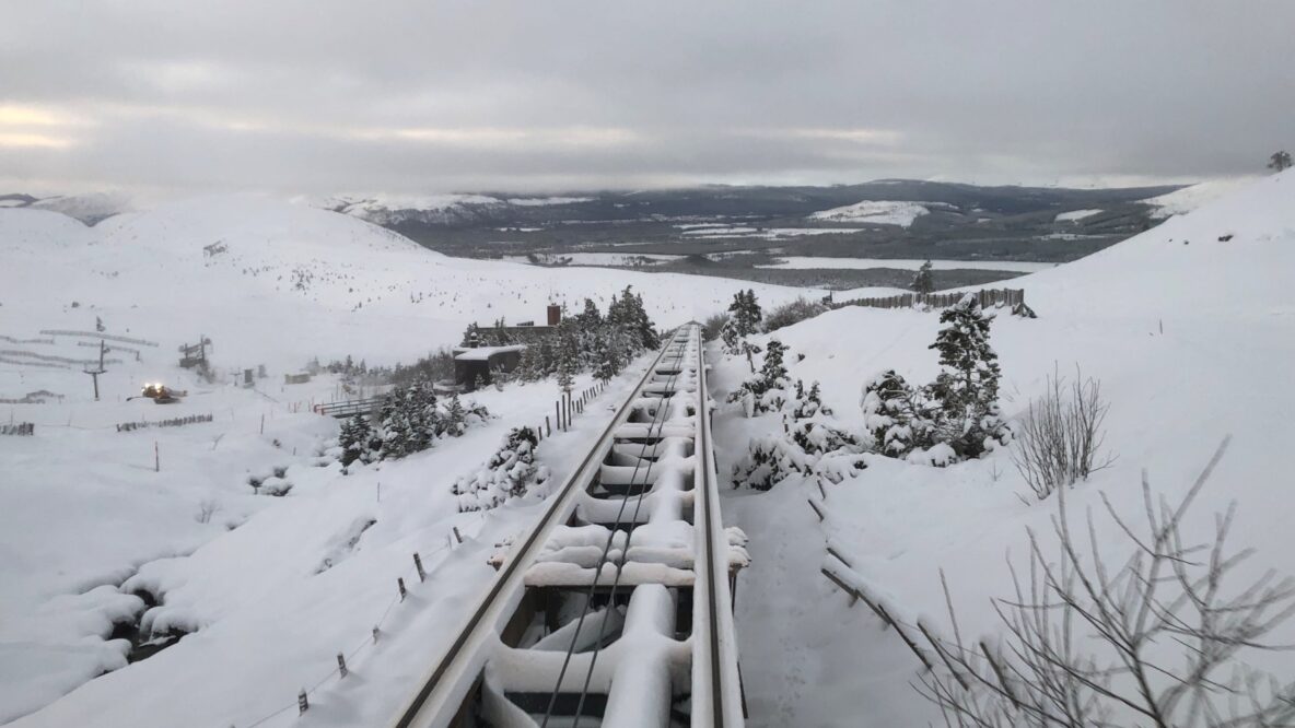 Snow covering train tracks running up the side of a mountain