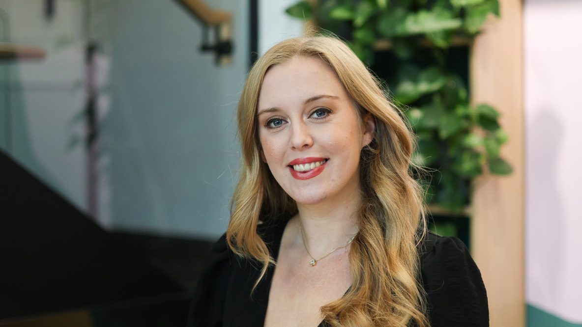Beth smiling in a modern office space