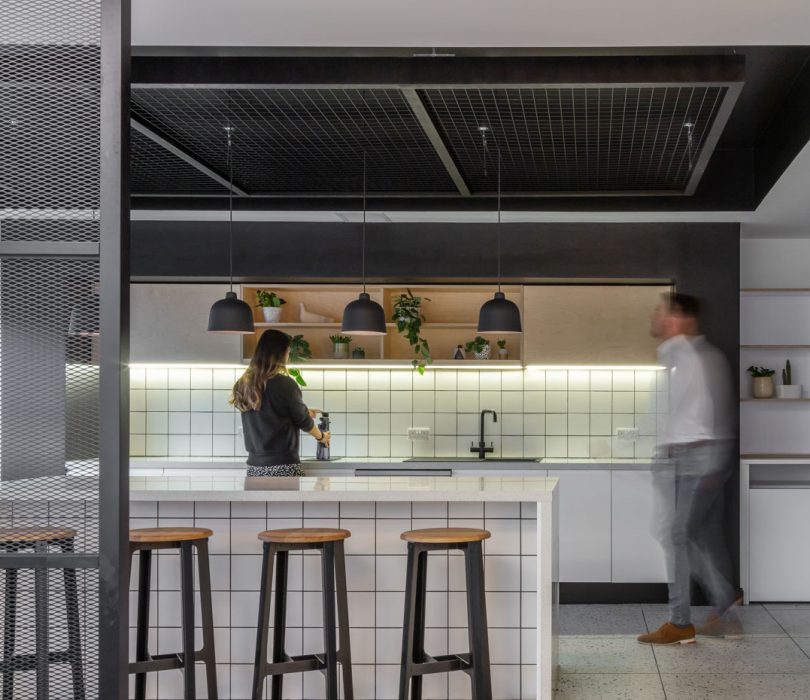Internal of a workplace kitchen with people chatting