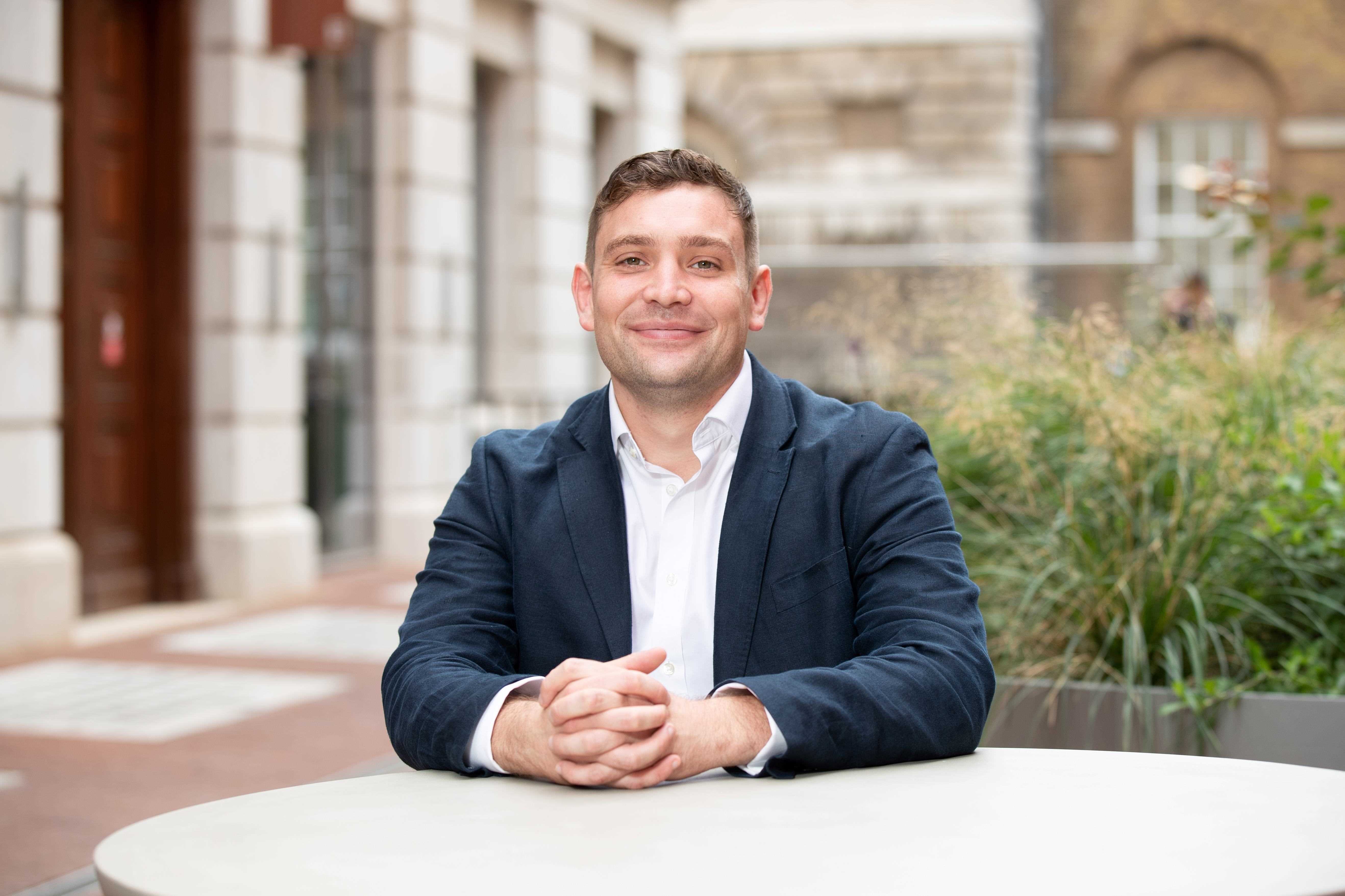 Matthew Appleton sitting at a roundtable smiling