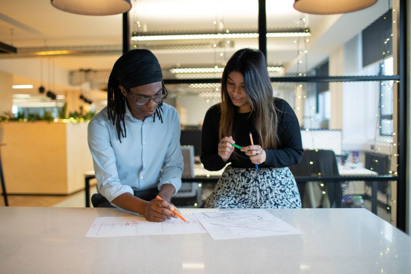 Two people looking at a drawing